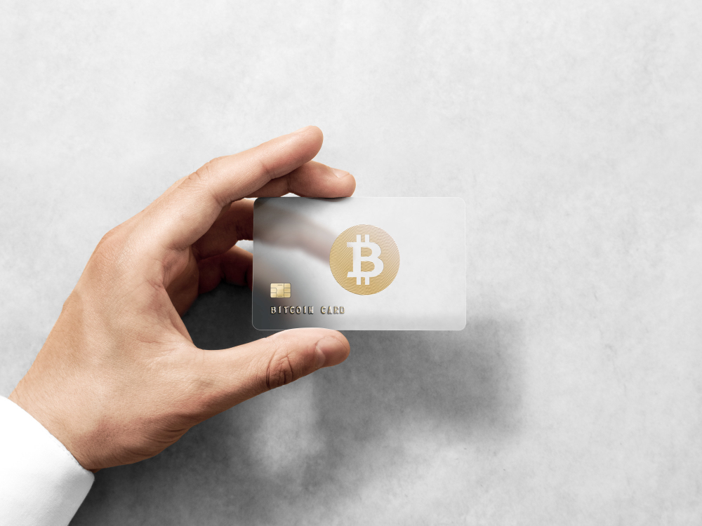 Main tenant le modèle de carte Bitcoin avec logo en or en relief